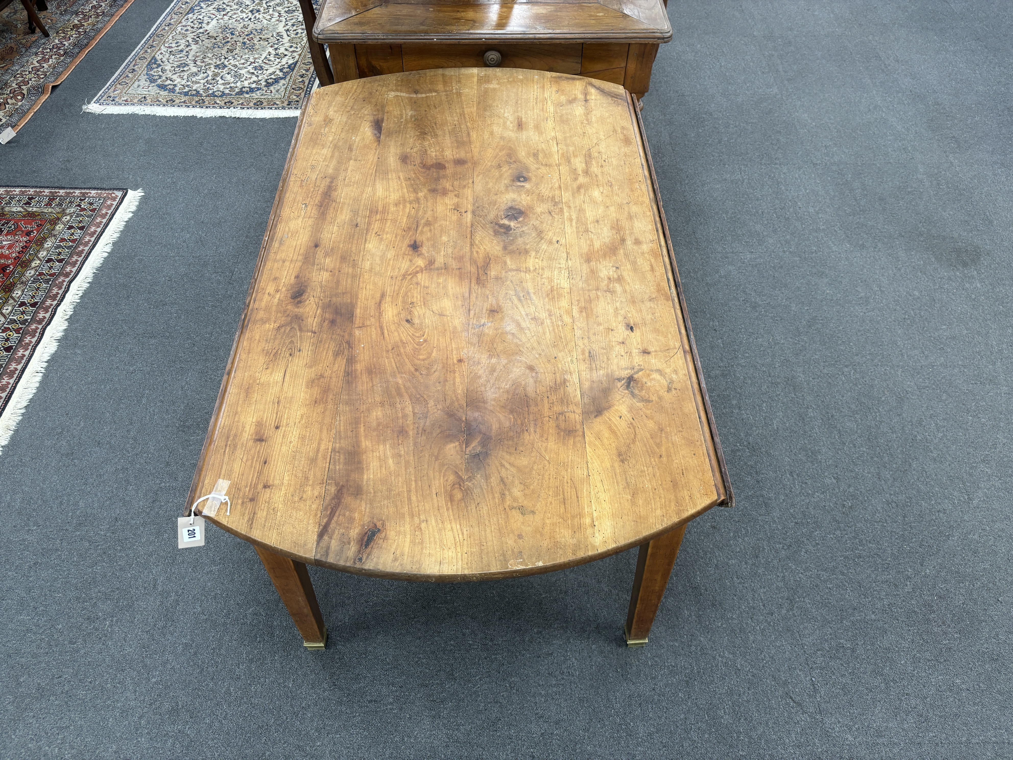 A 19th century French oval cherry drop flap kitchen table, width 136cm, depth 134cm extended, height 71cm